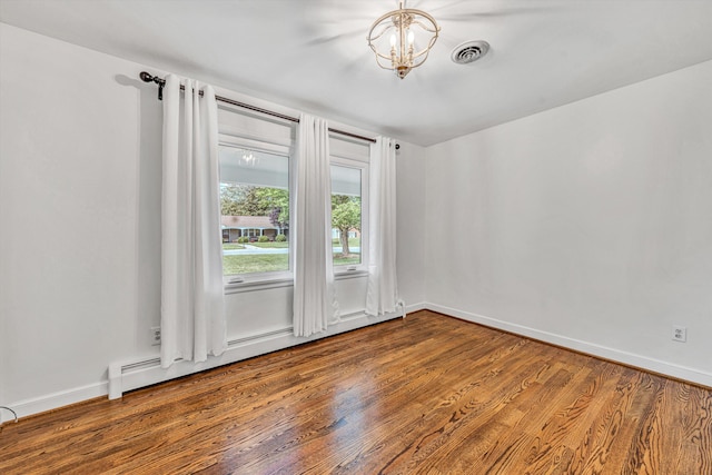 spare room featuring wood finished floors and baseboards