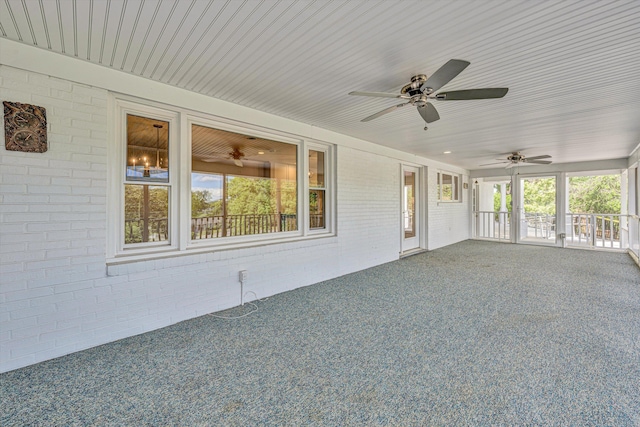 unfurnished sunroom with ceiling fan