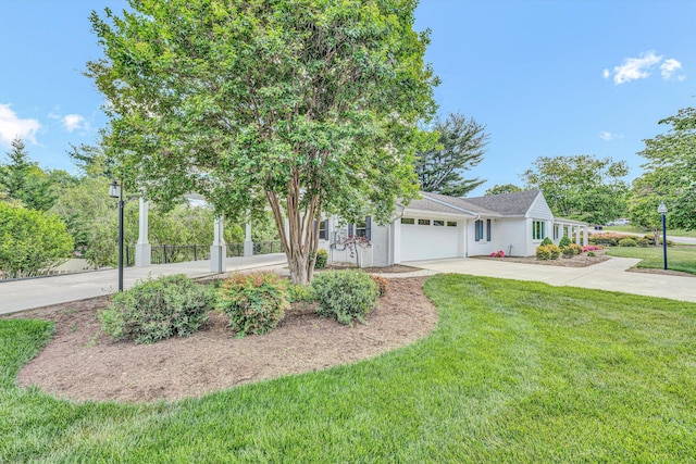 view of front of home featuring driveway, an attached garage, a front yard, and stucco siding