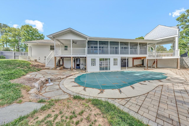 rear view of house with stairway, a ceiling fan, a sunroom, and a patio