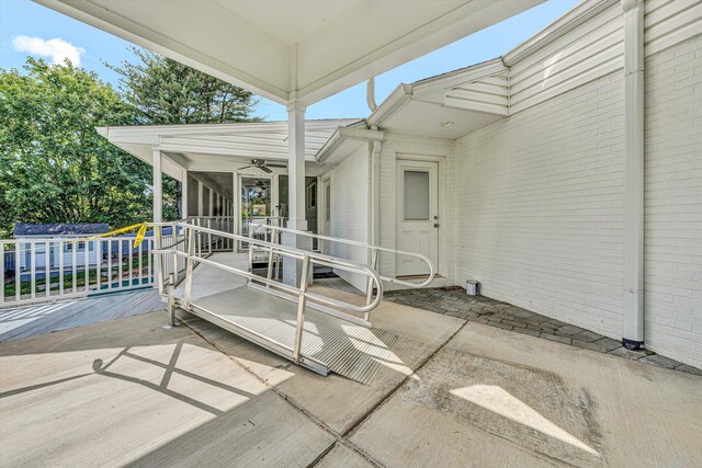 view of patio featuring a sunroom and a ceiling fan