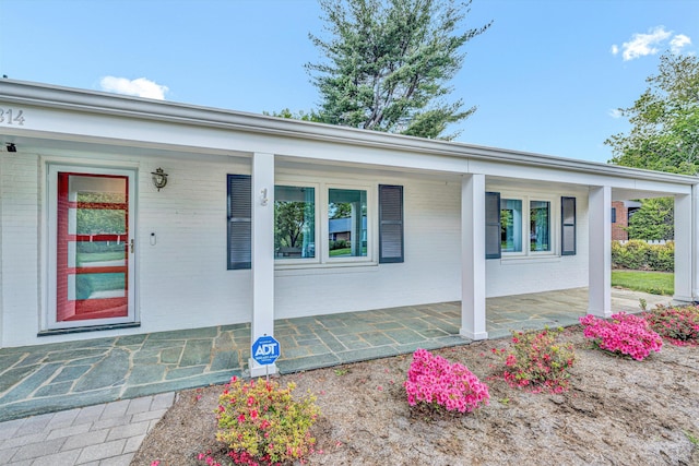 view of front of house featuring covered porch and brick siding