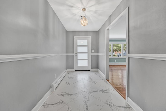 entryway with baseboard heating, a chandelier, marble finish flooring, baseboards, and a baseboard heating unit