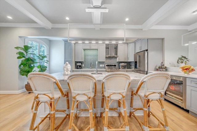400 Heather Ln, Huddleston, VA 24104 - kitchen with gray cabinetry, wall chimney exhaust hood, beam ceiling, appliances with stainless steel finishes, and light wood-style floors