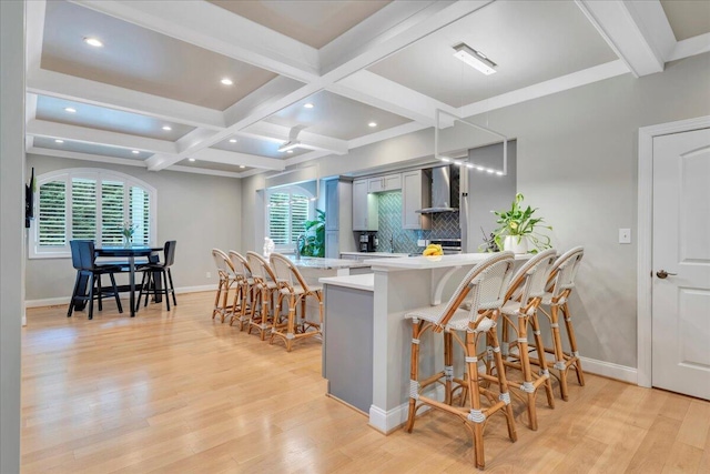 400 Heather Ln, Huddleston, VA 24104 - kitchen featuring wall chimney range hood, light countertops, light wood-style floors, baseboards, and beamed ceiling