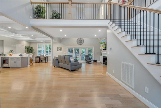 400 Heather Ln, Huddleston, VA 24104 - living room with light wood-type flooring, stairs, beverage cooler, baseboards, and beam ceiling