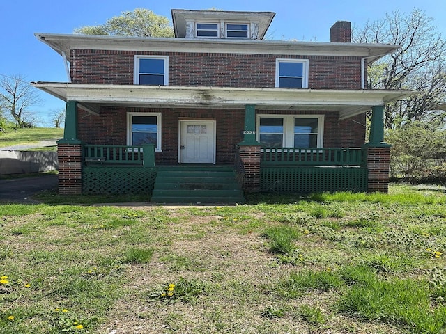 traditional style home with covered porch, brick siding, and a chimney