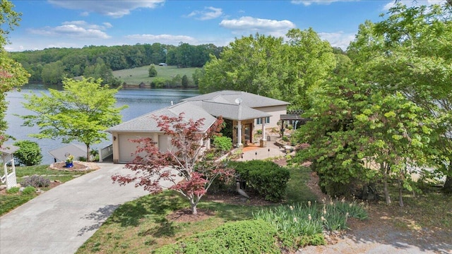 view of front of property with a water view, driveway, and a garage