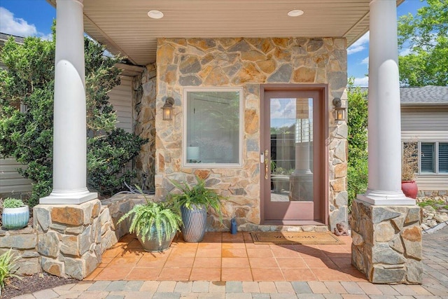 entrance to property featuring stone siding and covered porch