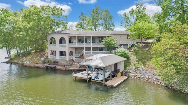 view of dock with a water view, a balcony, stairway, and boat lift