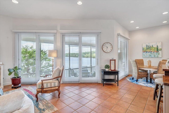 living area with a wealth of natural light, baseboards, light tile patterned floors, and recessed lighting