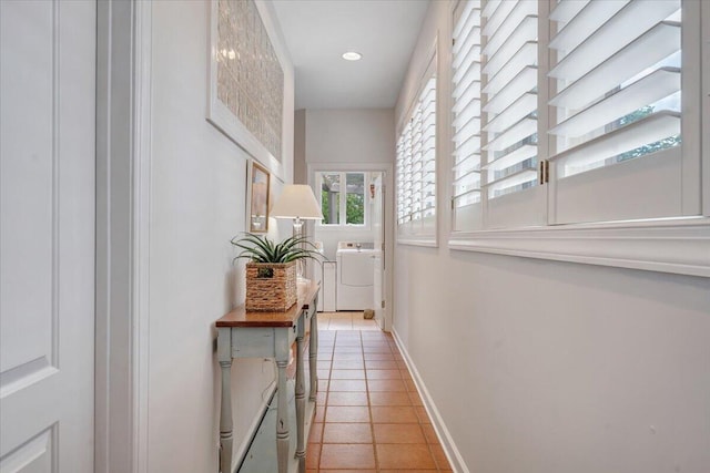 corridor featuring light tile patterned floors, baseboards, washer and dryer, and recessed lighting