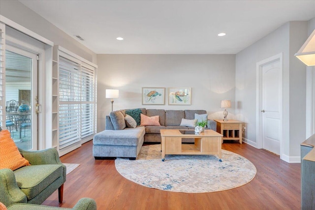 living room with recessed lighting, baseboards, visible vents, and wood finished floors