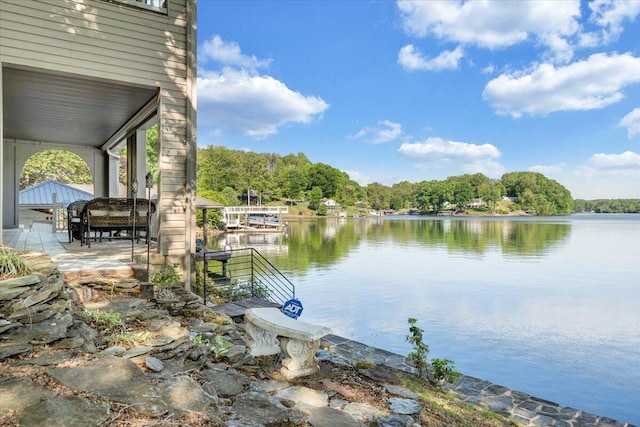 dock area with a water view and a wooded view