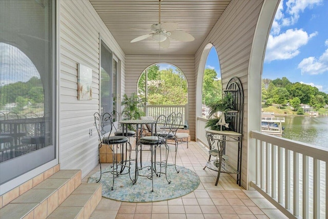 exterior space with a ceiling fan and a water view