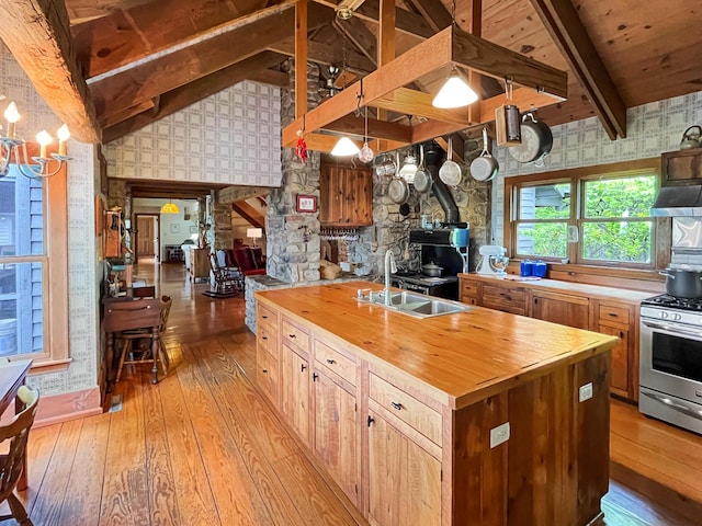 388 Hemlock Ridge Ln, Catawba, VA 24070 - kitchen with butcher block counters, wallpapered walls, a wood stove, stainless steel range with gas stovetop, and light wood finished floors
