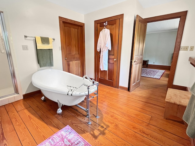 388 Hemlock Ridge Ln, Catawba, VA 24070 - bathroom with baseboards, a freestanding bath, and wood-type flooring