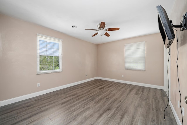 unfurnished room featuring baseboards, a ceiling fan, and wood finished floors