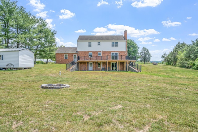 rear view of house featuring a chimney, brick siding, stairway, a wooden deck, and a fire pit