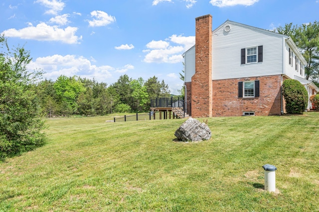 view of home's exterior with a chimney, a yard, stairway, and brick siding