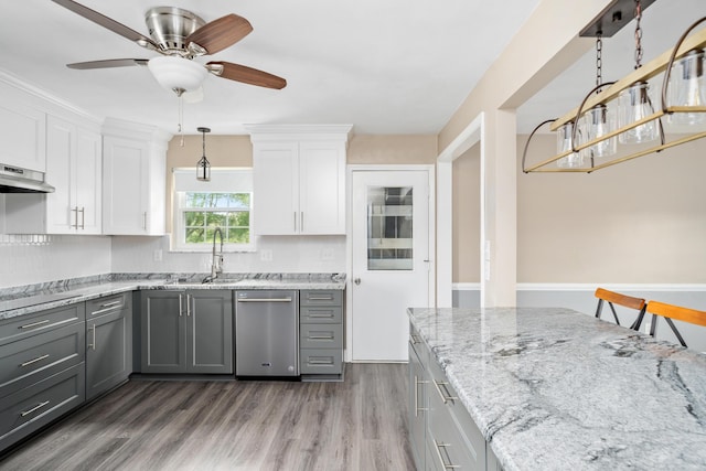 kitchen with gray cabinetry, stainless steel dishwasher, a sink, white cabinetry, and wood finished floors