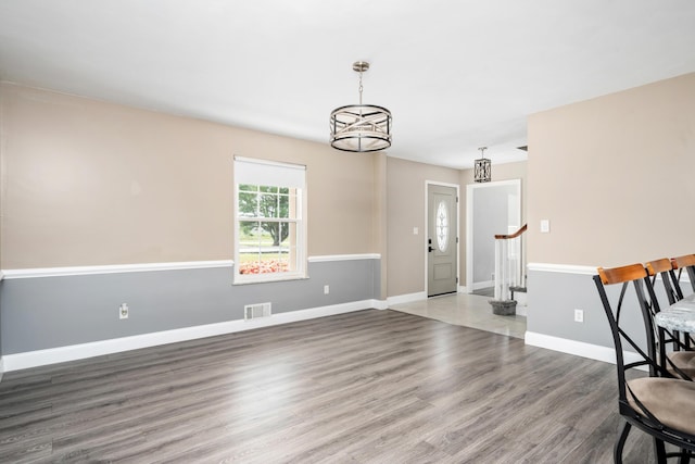 entrance foyer featuring stairs, baseboards, visible vents, and wood finished floors