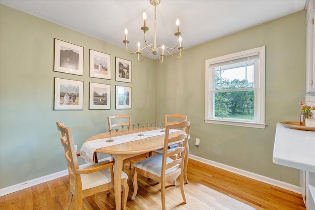 dining area featuring baseboards, a chandelier, and light wood-style floors