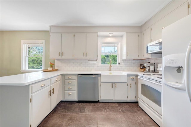 kitchen featuring appliances with stainless steel finishes, decorative backsplash, a sink, and a healthy amount of sunlight
