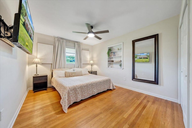 bedroom featuring baseboards, ceiling fan, and light wood-style flooring