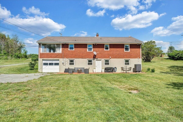 rear view of property featuring driveway, a lawn, central AC, a patio, and an attached garage