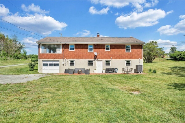 rear view of house with driveway, cooling unit, a yard, a patio, and an attached garage