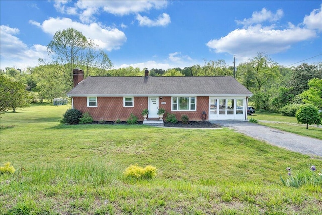 ranch-style home with a chimney, a front lawn, and brick siding