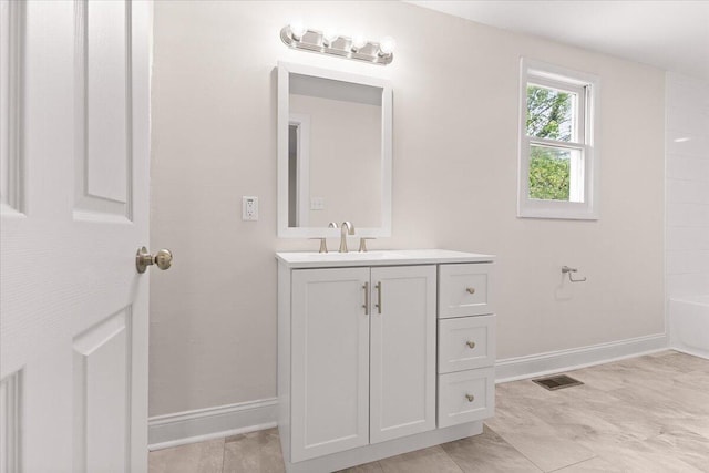 bathroom featuring vanity, baseboards, and visible vents