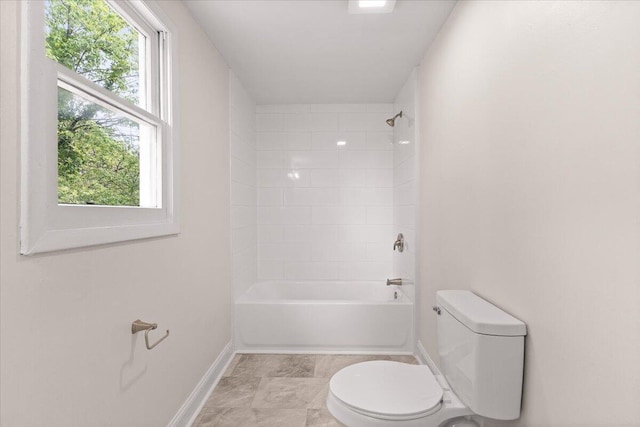 bathroom with baseboards, plenty of natural light, bathing tub / shower combination, and toilet
