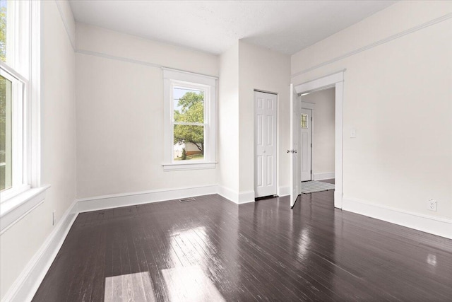 unfurnished bedroom with wood-type flooring, baseboards, and a closet