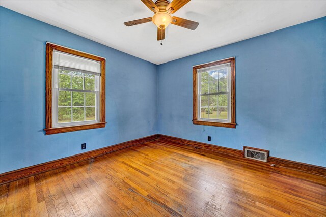 7080 Oak Level Rd, Bassett, VA 24055 - empty room with wood-type flooring, a ceiling fan, baseboards, and a wealth of natural light