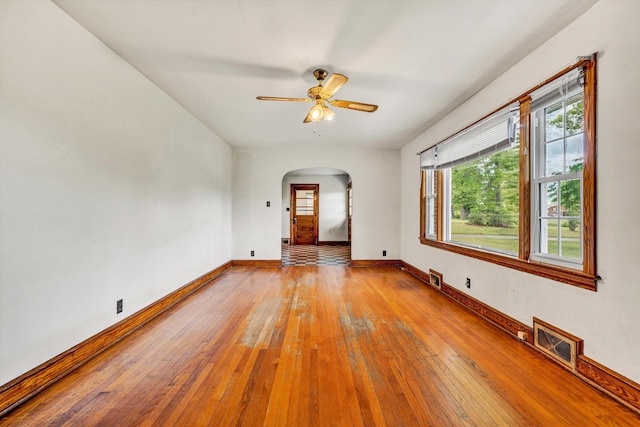 7080 Oak Level Rd, Bassett, VA 24055 - empty room with ceiling fan, visible vents, arched walkways, baseboards, and wood-type flooring