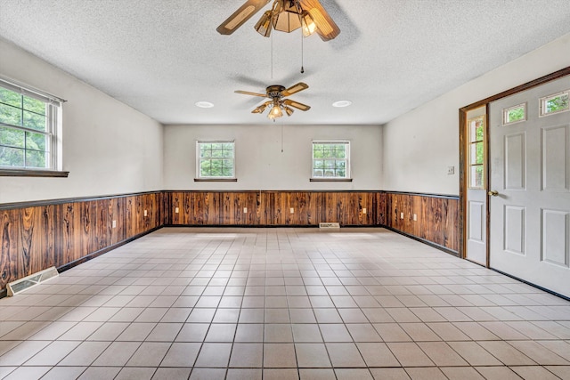 7080 Oak Level Rd, Bassett, VA 24055 - foyer entrance featuring wooden walls, ceiling fan, a textured ceiling, a wainscoted wall, and visible vents