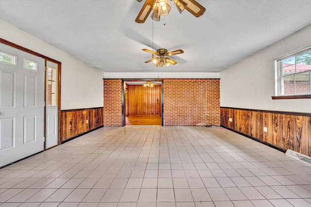 7080 Oak Level Rd, Bassett, VA 24055 - foyer entrance with a textured ceiling, ceiling fan, a wainscoted wall, and wooden walls