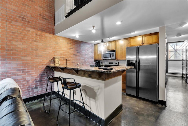 kitchen with a peninsula, concrete flooring, a breakfast bar, and stainless steel appliances