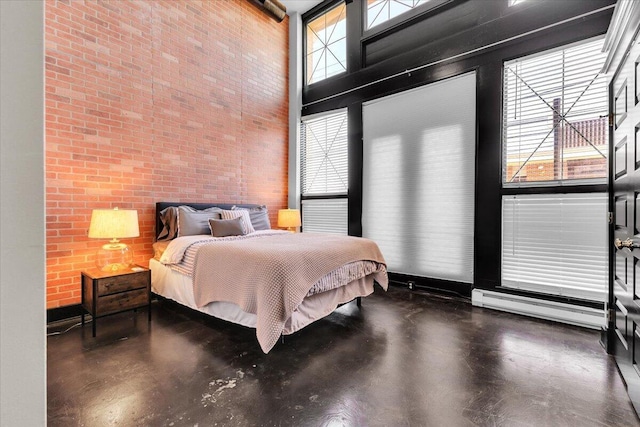 bedroom featuring a baseboard radiator, a high ceiling, and brick wall