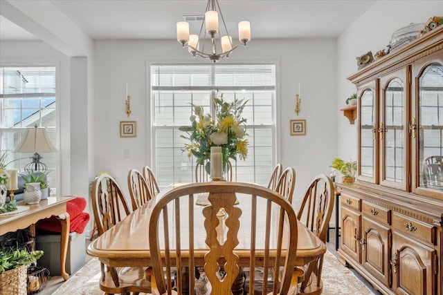 dining space with visible vents, a notable chandelier, and a wealth of natural light