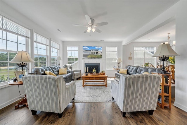 living room featuring baseboards, a ceiling fan, and wood finished floors