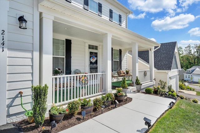 view of exterior entry with a garage and covered porch