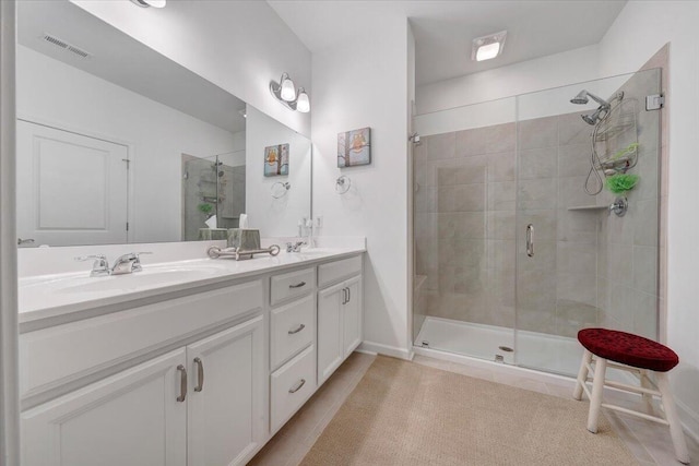 full bath featuring a sink, a stall shower, double vanity, and visible vents