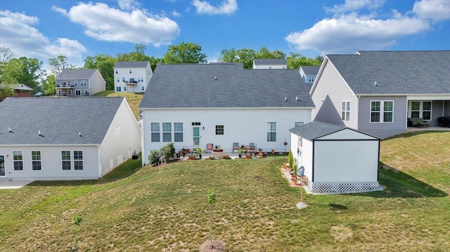 back of property featuring a storage shed, an outbuilding, a residential view, a yard, and a patio