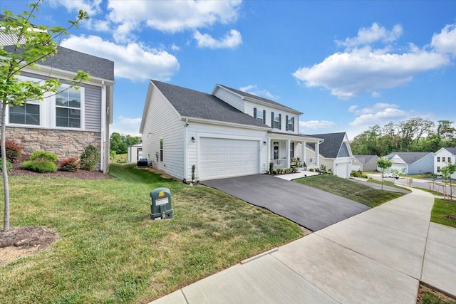 view of front of house featuring an attached garage, driveway, stone siding, and a front lawn