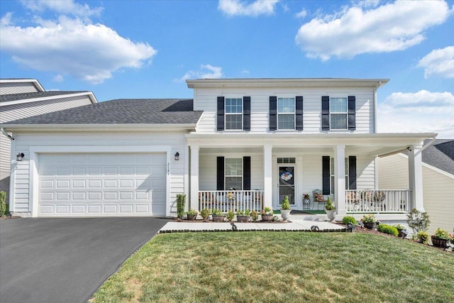 traditional home featuring a porch, a garage, aphalt driveway, and a front yard