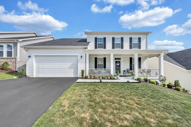 traditional-style house featuring a garage, a front lawn, a porch, and driveway