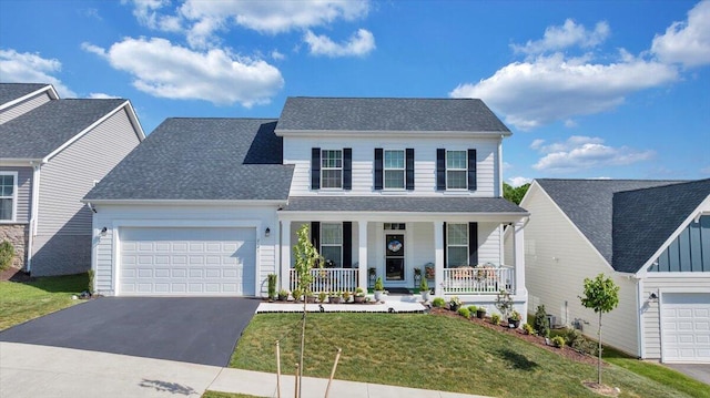 traditional home with a front lawn, covered porch, a shingled roof, an attached garage, and driveway